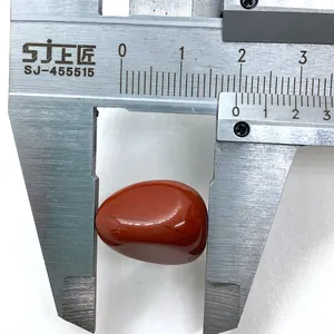 Gepolijste roodbruine natuursteen gemeten met schuifmaat, afmeting circa 22 mm