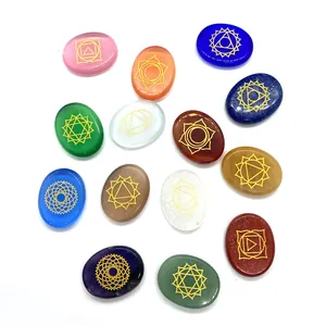 Set of 13 oval chakra healing stones with golden symbols on polished natural crystals
