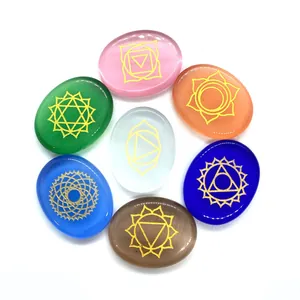 Polished chakra stones set with golden symbols in an oval shape for energy healing