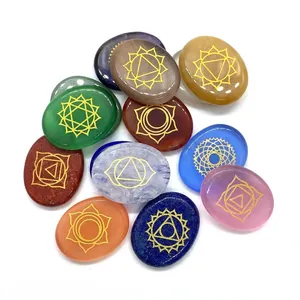Polished chakra stone set with golden spiritual symbols on assorted colorful oval crystals
