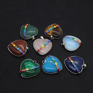 Acht Herz-Edelstein-Anhänger mit sieben Chakra-Steinen in Metallbändern auf Schwarz