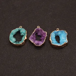 Drie onregelmatige druzy agaat hangers in groen, paars en blauw met goudkleurige rand