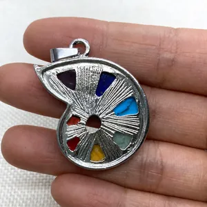 Detailed macro view of snail shaped pendant with colorful chakra crystals in silver casing