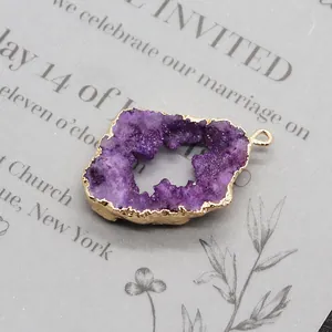 Macro-opname van een paarse druzy geode hanger met een elegante vergulde metalen rand