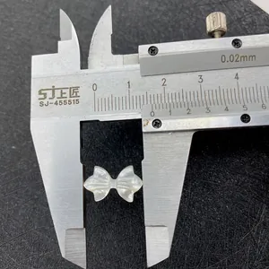 Makroaufnahme: 12mm Breite eines weißen Schmetterling-Perlmuttanhängers mit Messschieber