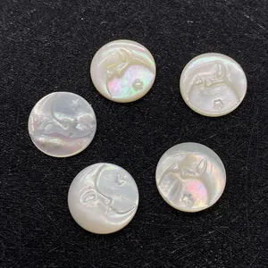 Makro-Detail von 15mm Muschelperlen mit Mond- und Sternrelief auf schwarzem Grund