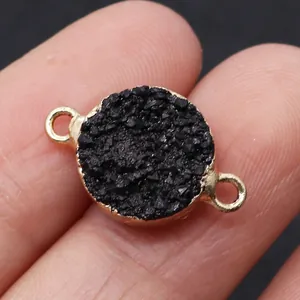 Macro shot of circular druzy quartz connector with black crystals and gold plated double loops