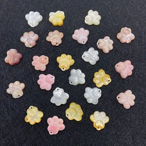 Makroaufnahme von Pfoten-Anhängern aus Naturmuscheln in Rosa und Weiß für DIY-Schmuck