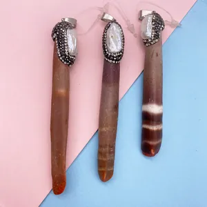 Dettaglio di pendenti in agata marrone naturale con perle barocche e cristalli