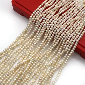 Macro di perle naturali d'acqua dolce 2-3mm con lucentezza su un supporto espositivo rosso