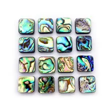 Dettaglio macro di sedici cabochon quadrati in conchiglia abalone con texture arcobaleno