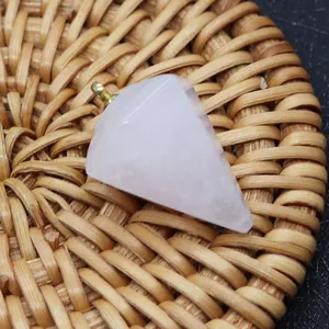 Nahaufnahme eines facettierten Rosenquarz-Anhängers mit Goldöse auf Geflecht