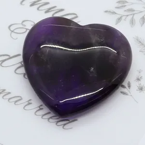 Macro di pietra di ametista viola lucida a forma di cuore su un vassoio decorativo