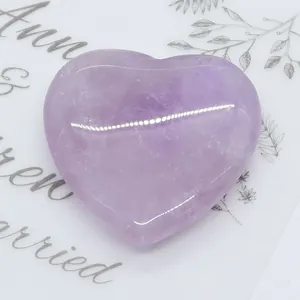 Macro di una pietra di ametista viola a forma di cuore con venature naturali del cristallo