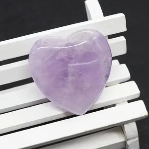 Dettaglio macro di ametista lucidata a forma di cuore con trama naturale su legno