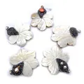 Makro-Detail handgeschnitzter Muschelblumenanhänger mit funkelnden Strass-Zentren