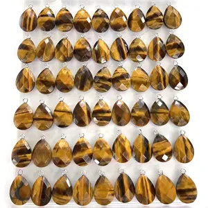 Pendentifs gouttes en œil de tigre facetté avec anneaux argentés disposés sur plateau