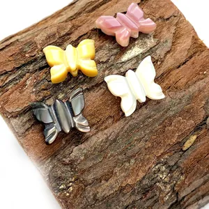 Lot de quatre pendentifs papillon en nacre naturelle rose, jaune, blanc et noir
