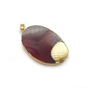 Detail of oval red agate pendant with gold metal edges and white seashell charm
