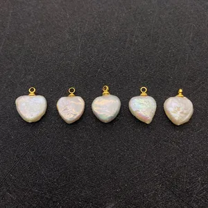 Détail macro de pendentifs en perles d'eau douce baroques en forme de cœur et boucles d'or