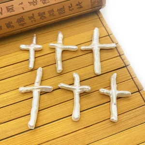 Cross-shaped natural freshwater baroque pearls with iridescent luster on bamboo mat