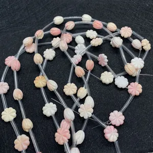 Gros plan de perles en forme de tulipe roses et orange pour création de bijoux DIY
