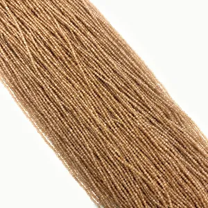 Dettaglio macro di perline in pietra naturale sfaccettata marrone chiaro per gioielli