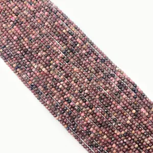 Macro detail of faceted natural rhodonite beads showing pink and black textures