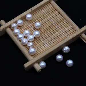 Macro-opname van witte bijna ronde zoetwaterparels met gaten voor DIY-sieraden maken