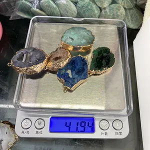 Κοντινό πλάνο με πέντε πολύχρωμα μενταγιόν druzy σε ζυγαριά που ζυγίζει 41,94 γραμμάρια