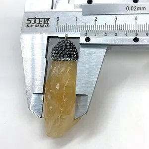 Vue macro de la mesure de largeur d'un pendentif en citrine avec un pied à coulisse