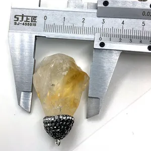 Mesure de la largeur d'un pendentif en citrine naturelle avec un pied à coulisse en métal