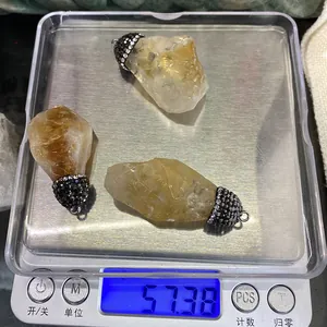 Mesure du poids de trois pendentifs en citrine brute avec capuchons sertis de cristaux