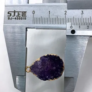 Detailed view of purple druzy stone pendant being measured with a 20mm width caliper