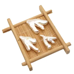 Natural baroque freshwater pearl beads in claw shape on a bamboo tray for DIY jewelry