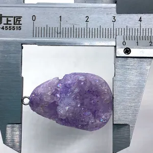 Macro detail van natuurlijke iriserende amethist hanger gemeten met een schuifmaat