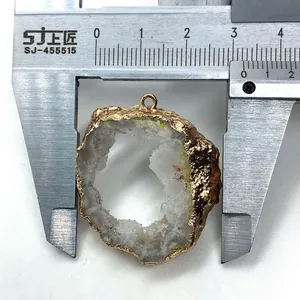 Calipers measuring a natural crystal geode pendant with gold plating for DIY jewelry