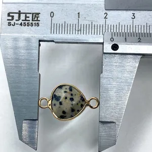 Macro shot measuring an 18mm Dalmatian Jasper teardrop pendant with a gold bezel