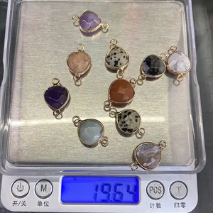 Macro shot of nine heart-shaped natural stone pendants on a digital scale weighing 19.64g