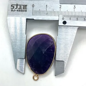 Macro shot measuring faceted amethyst teardrop pendant width with silver metal caliper