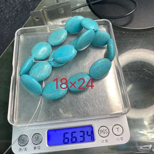 Türkise ovale Perlen auf der Waage, die Größe 18x24mm und Gewicht 66,34g zeigen