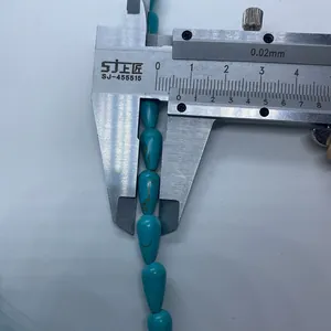 Détail macro montrant la mesure d'une perle de turquoise bleue avec un étrier