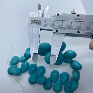 Macro shot of turquoise teardrop beads with dimension measurement using a caliper