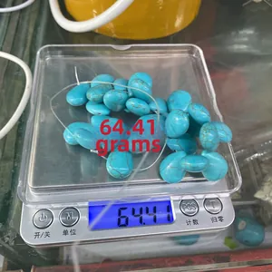 Detailed view of 100g loose turquoise drop beads weighing on a digital scale