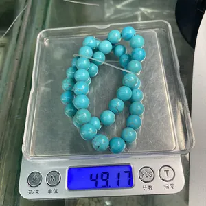 Mesure du poids de 49,17g pour des perles rondes en turquoise sur une balance