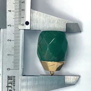 Macro shot of a faceted green gemstone pendant being measured with a silver caliper