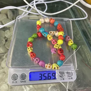 Detail shot of multi-colored skull beads on a digital scale weighing 35.69 grams
