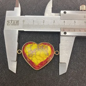 Macro view of a 35mm heart-shaped natural stone pendant with gold-plated metal edging