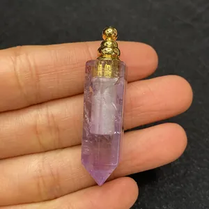 Macro di un ciondolo a boccetta di profumo in ametista viola con tappo dorato