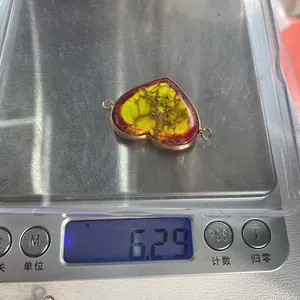 Macro view of a 6.29g heart-shaped turquoise connector with metallic gold edging